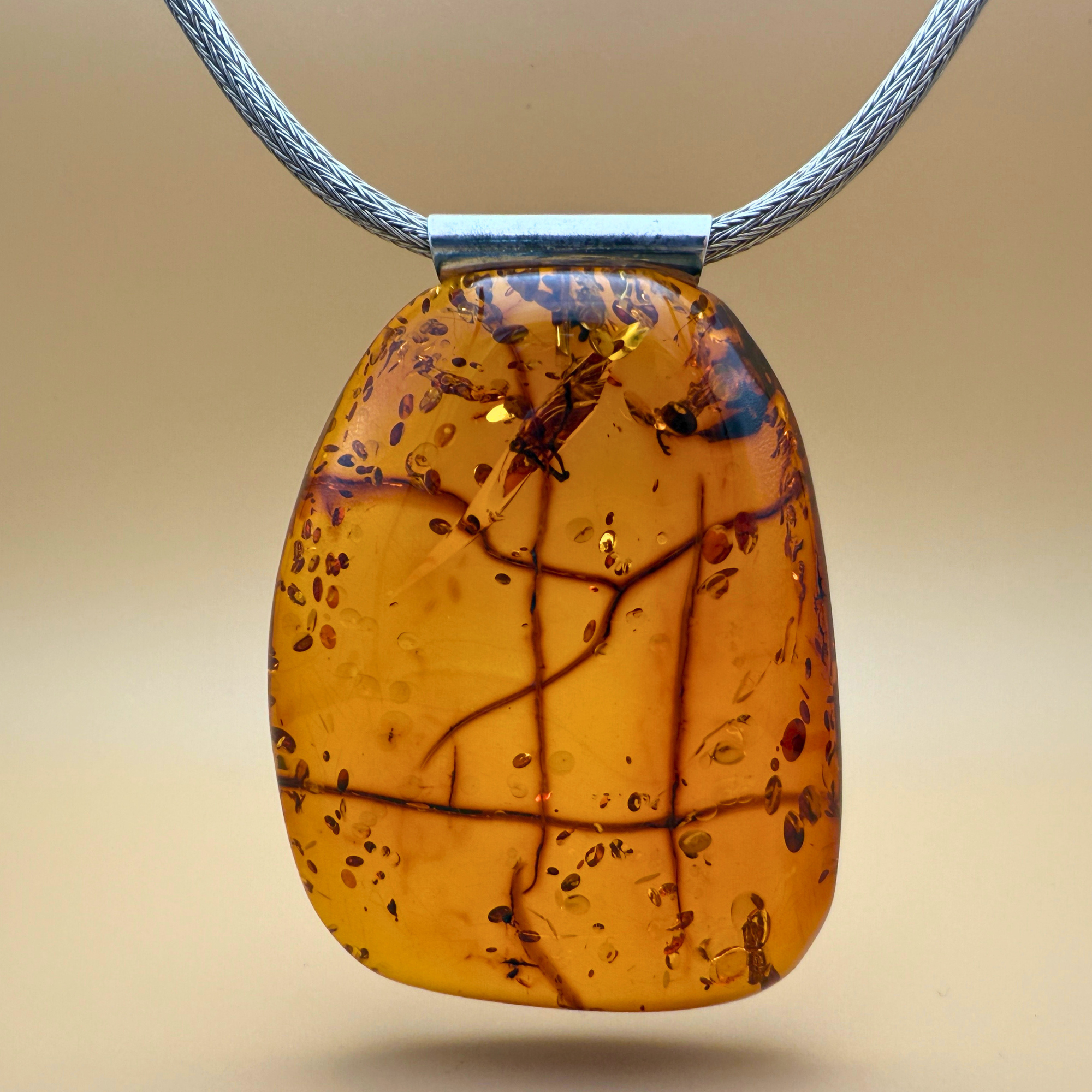 Stort cognacfarvet ravvedhæng med rør i sterlingsølv