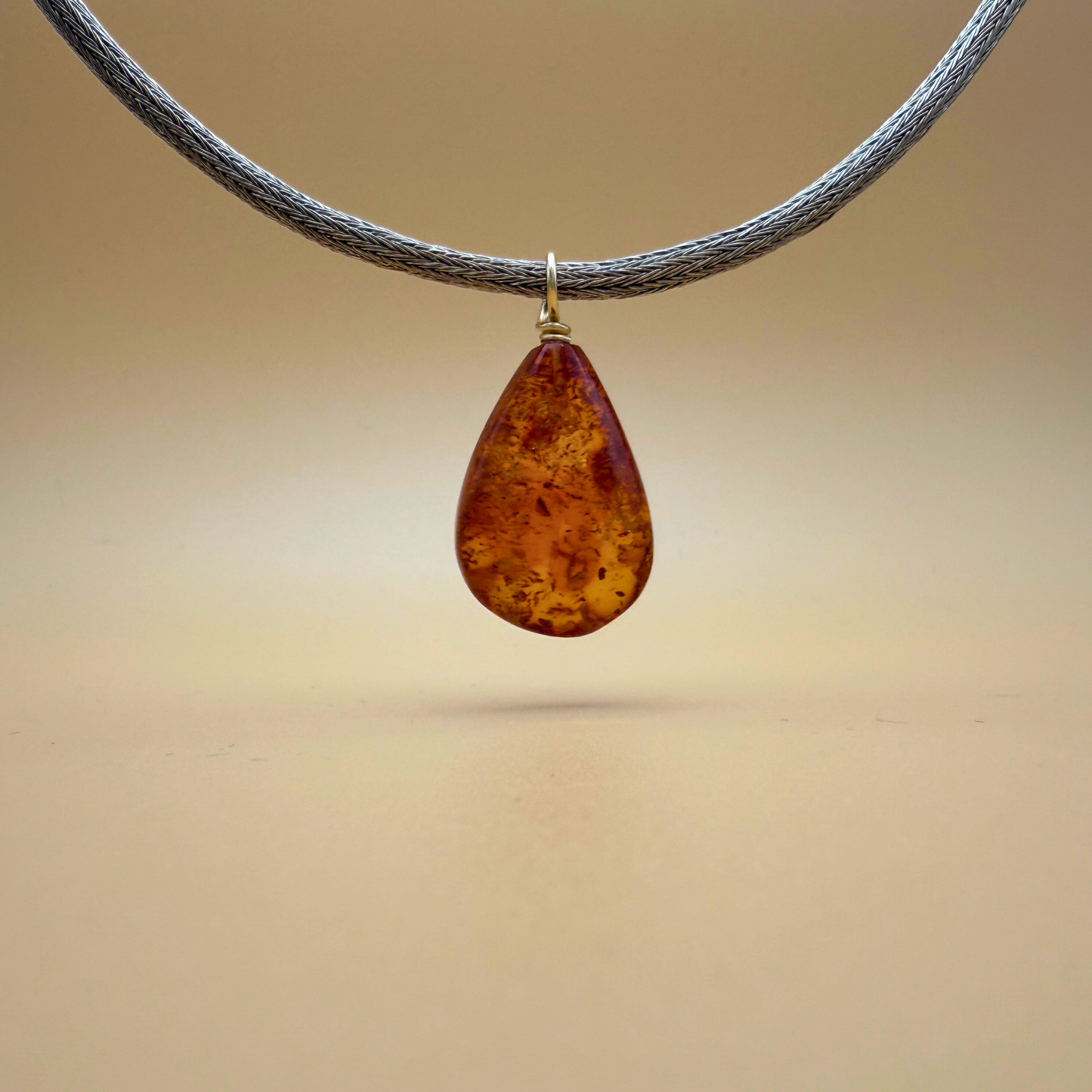 Teardrop-shaped amber pendant with gold on a handknitted chain - Ravgaard