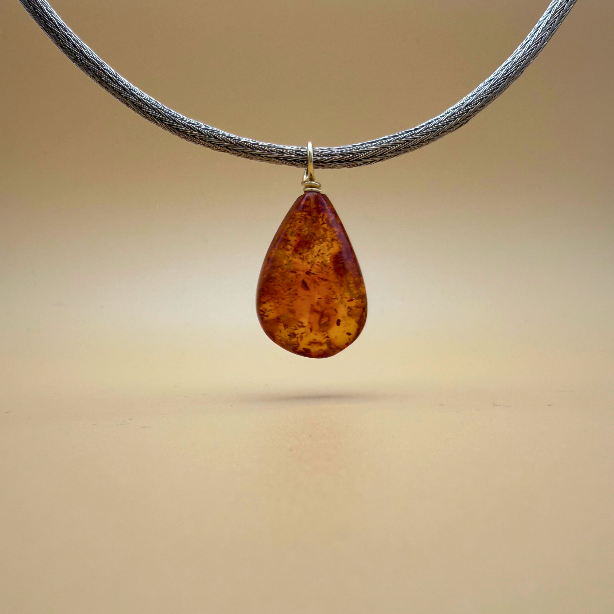 Teardrop-shaped amber pendant with gold on a handknitted chain - Ravgaard