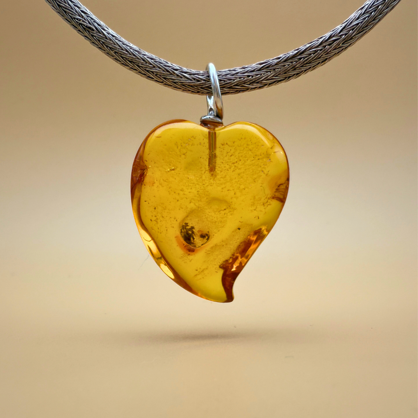 Bernsteinanhänger mit tanzendem Herz in klarem Citringelb