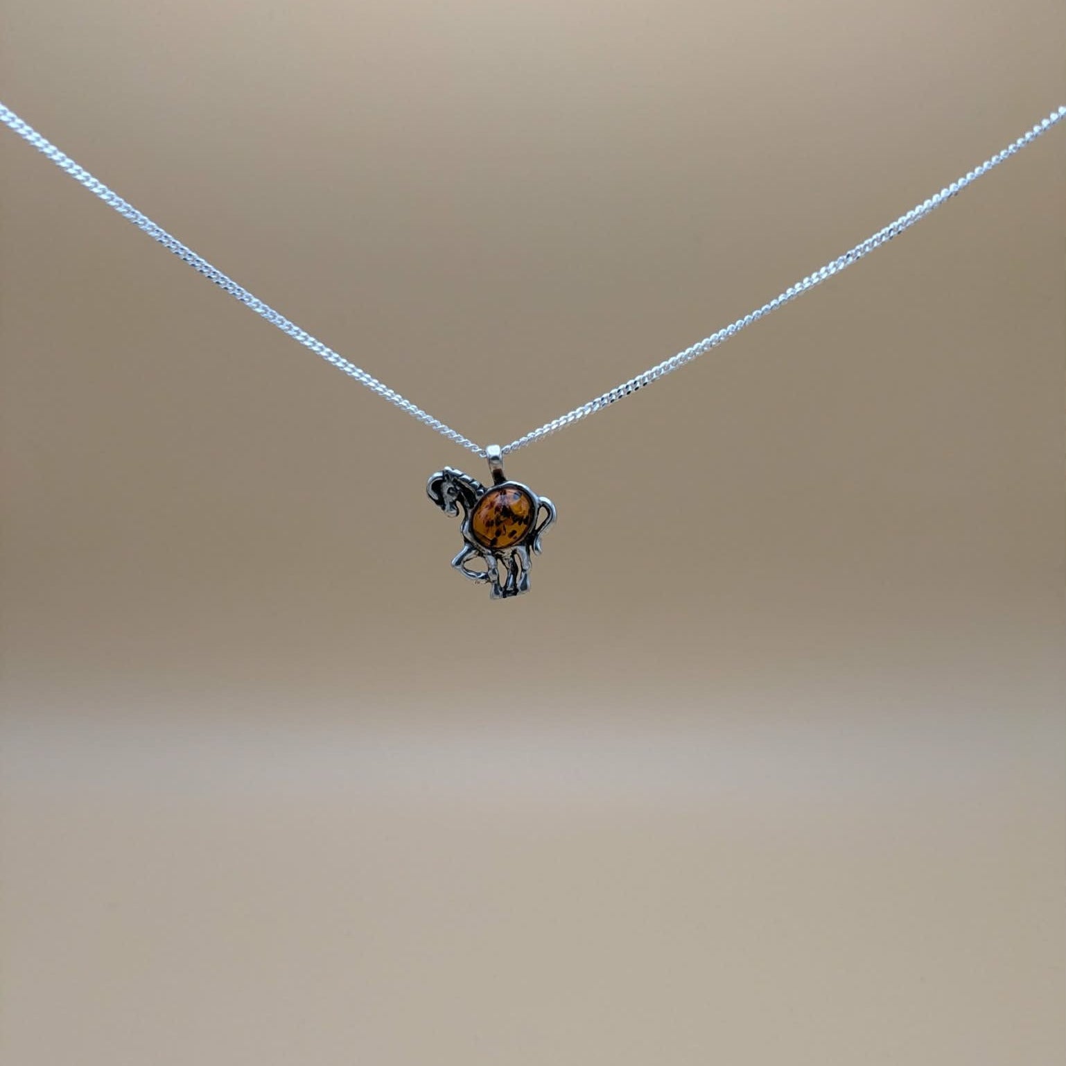 Horse pendant in silver with cognac amber