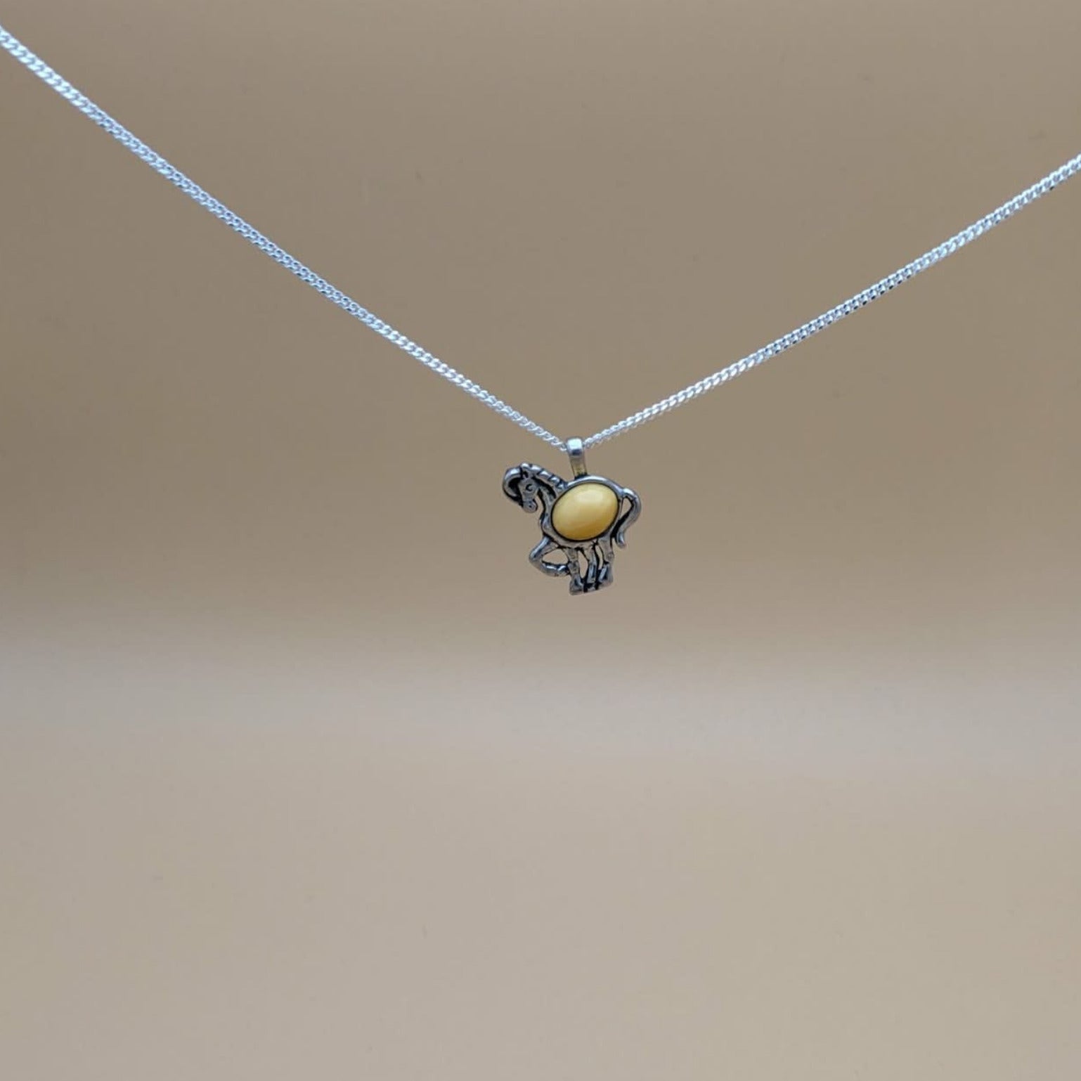 Horse pendant in silver with milky amber