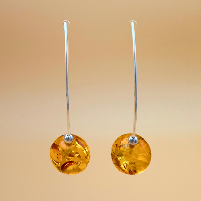 Amber earrings dangling on silver wire